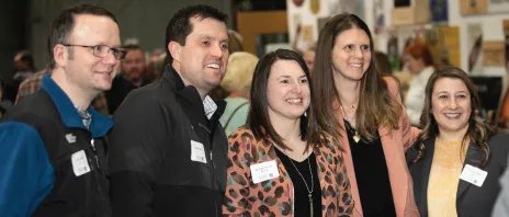 A group of people gathered at the wine festival smiling together.